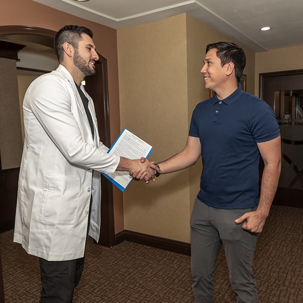 Dr. Marabeh shaking hands with a young man