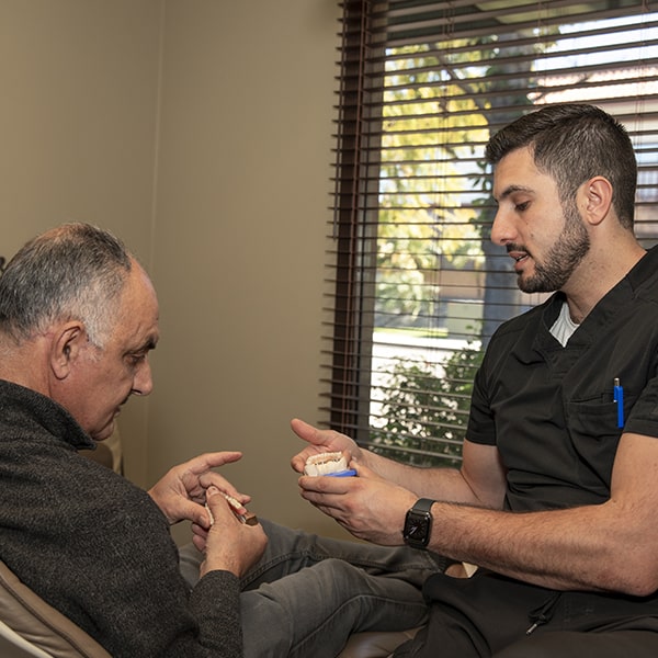 Dr. Marabeh talking to an older man about his treatment