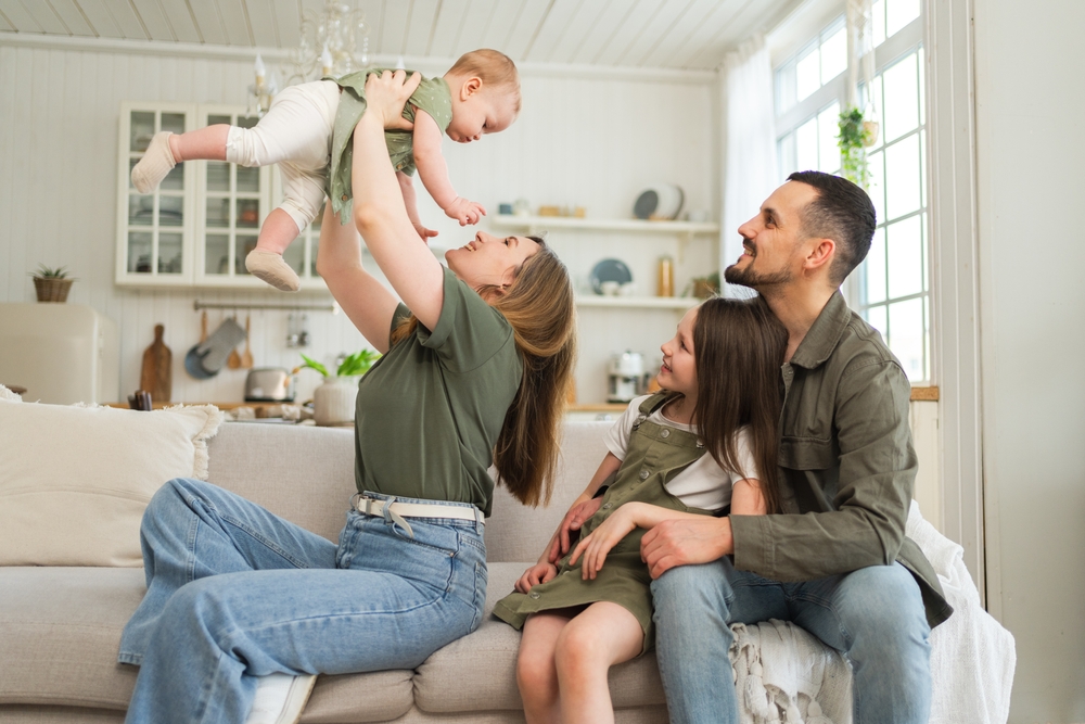 Parents playing with their two young children at home