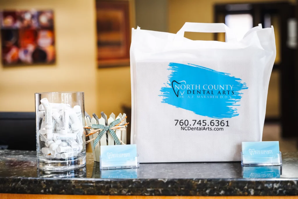 North County Dental Arts welcome bag and business cards at the front desk