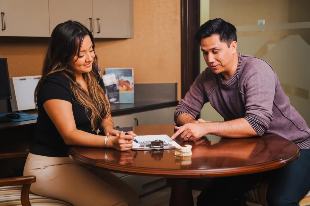 Team member going over paperwork with a patient at a consultation table