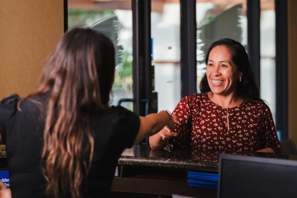 Friendly front desk staff greeting patient at North County Dental Arts